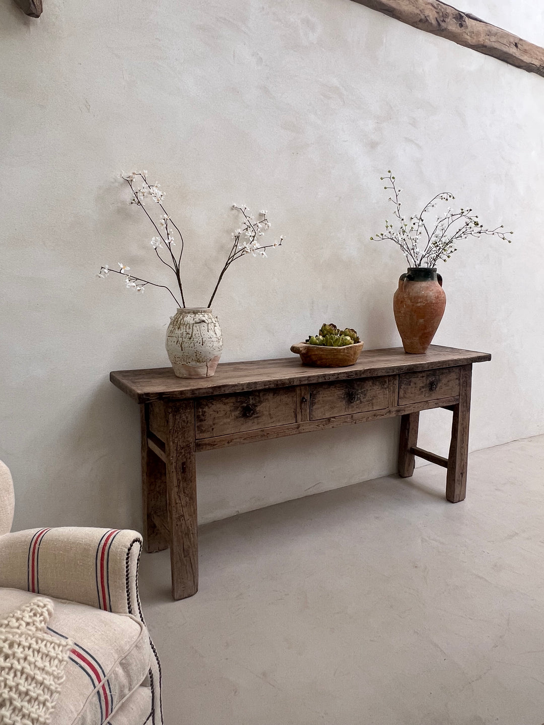 Wooden step stool with decorative items on a light gray floor.