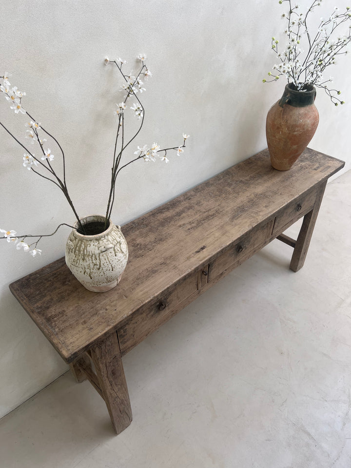 Wooden bench with two ceramic vases and branches on a light background