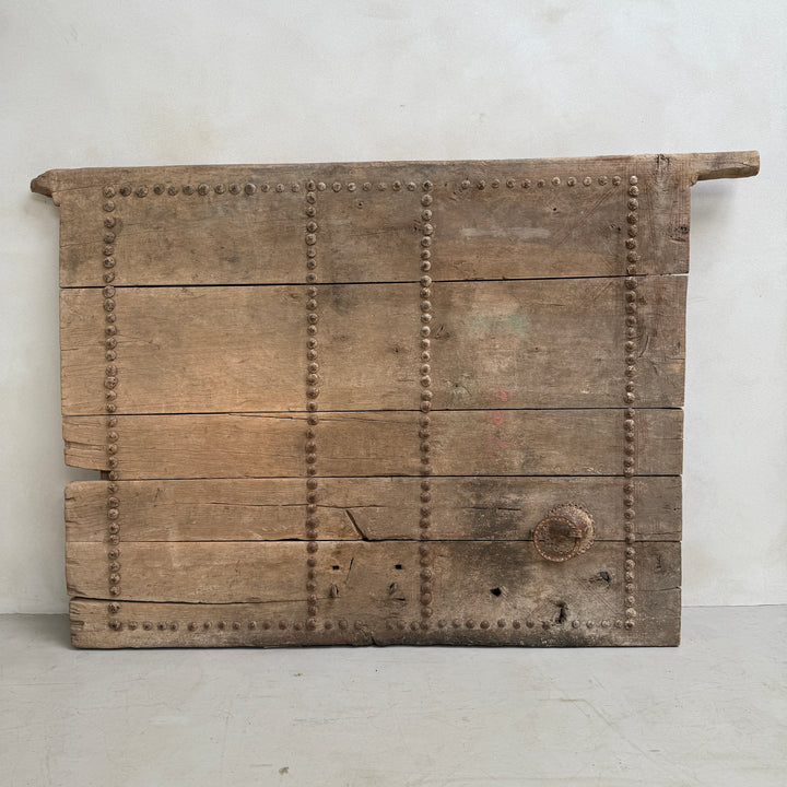 Vintage wooden panel with metal rivets on a white background