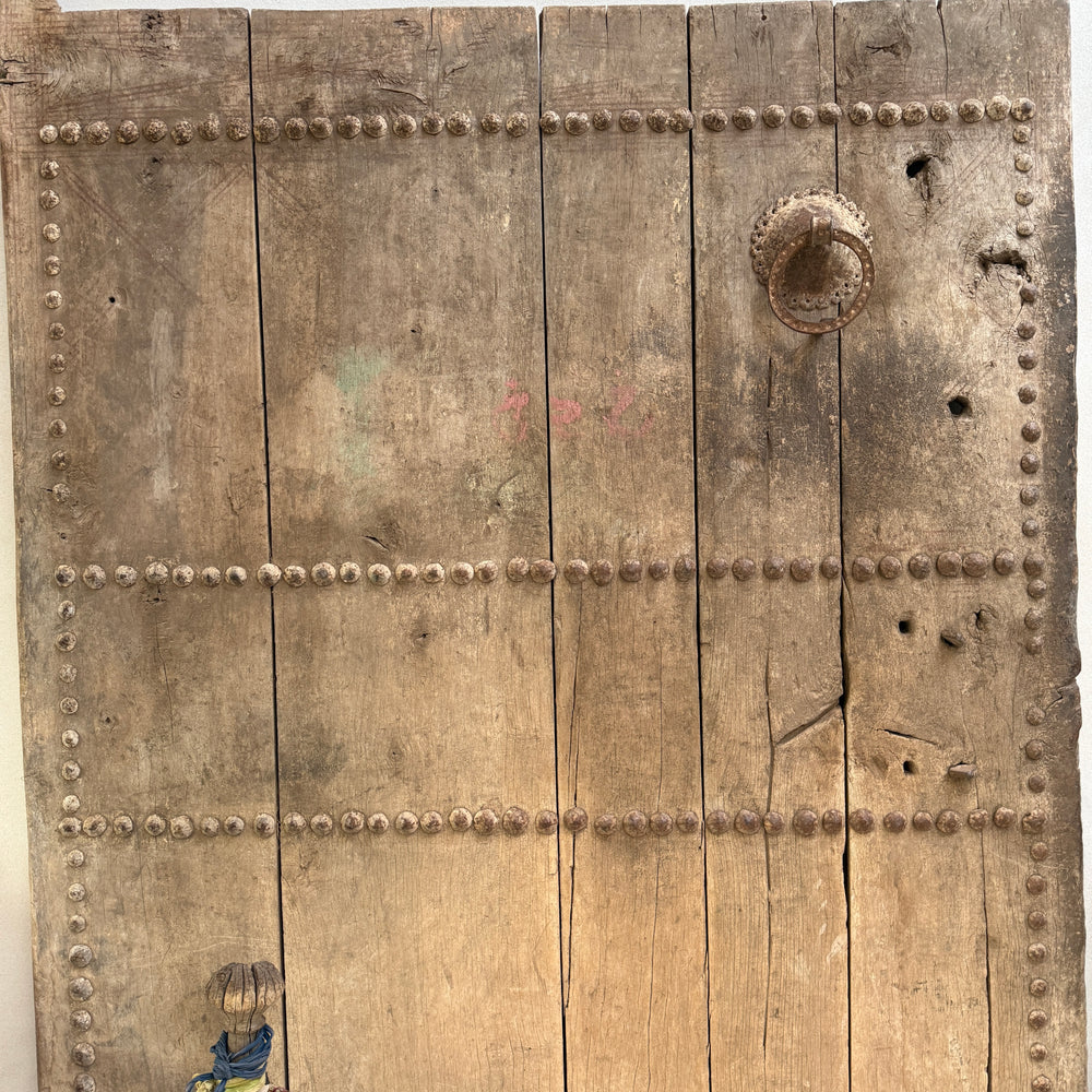 Vintage wooden door with metal rivets and a handle on a white background