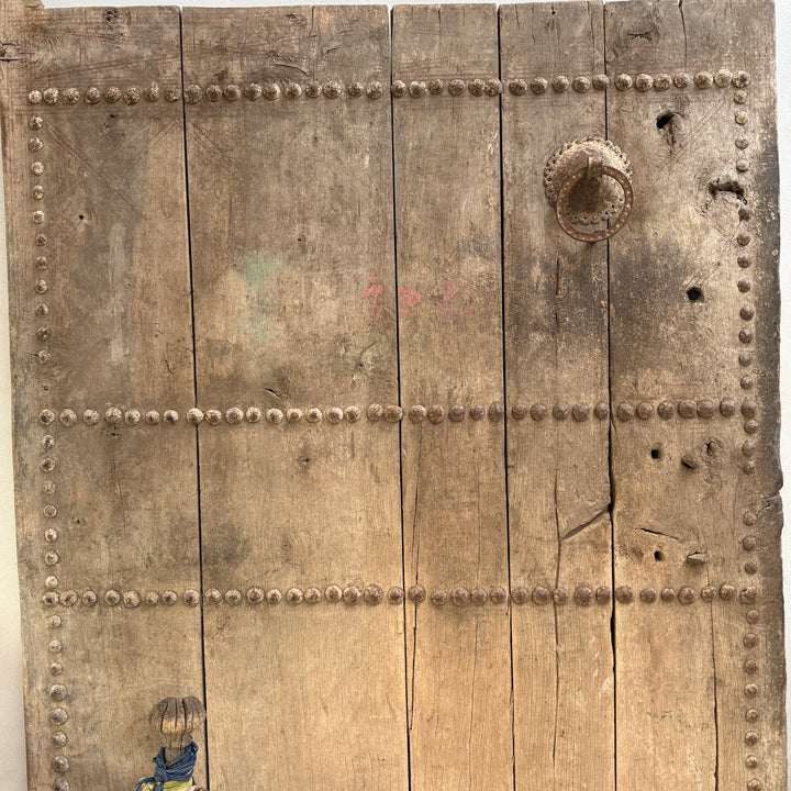Vintage wooden door with metal rivets and a handle on a white background
