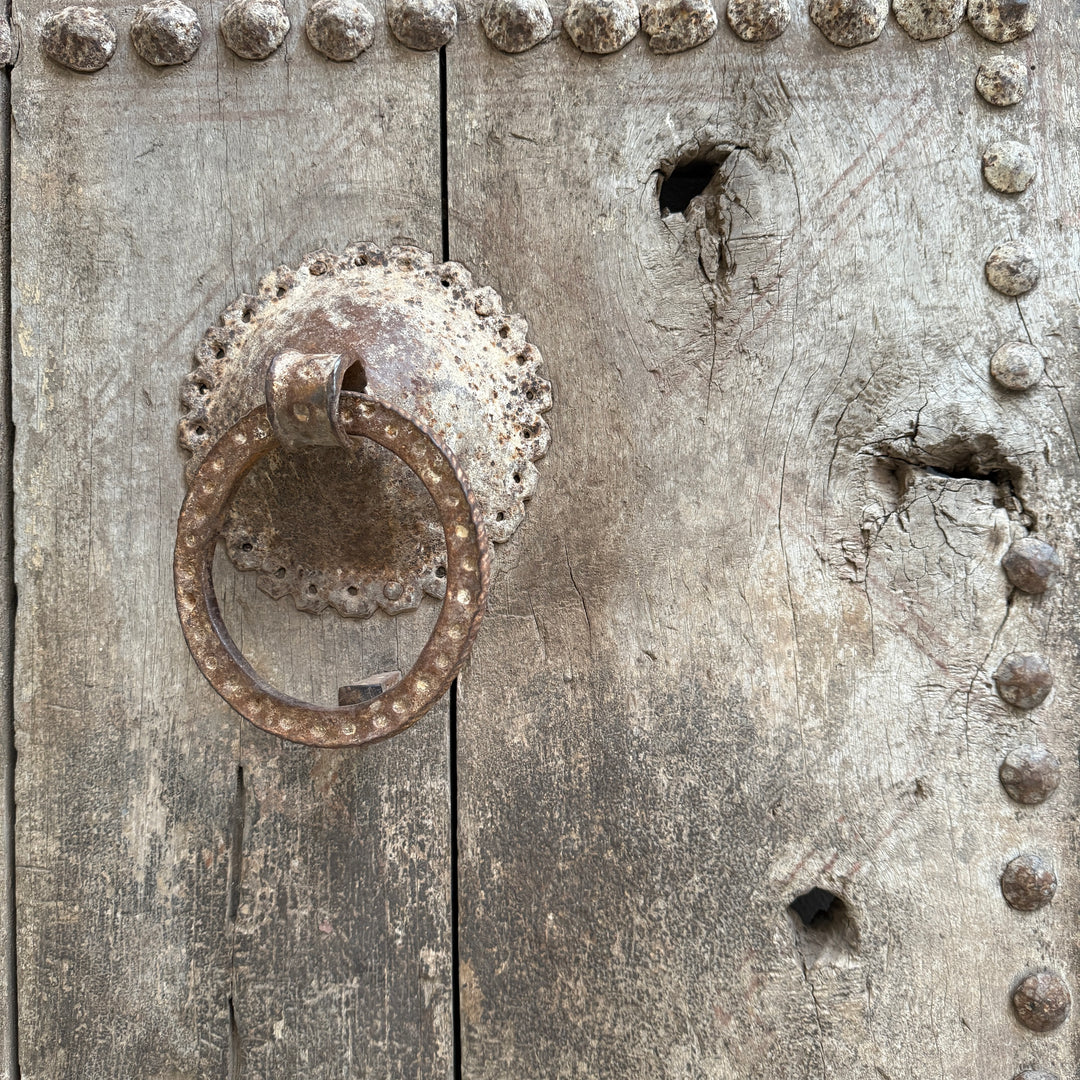 Rustic metal door handle on a textured wooden door