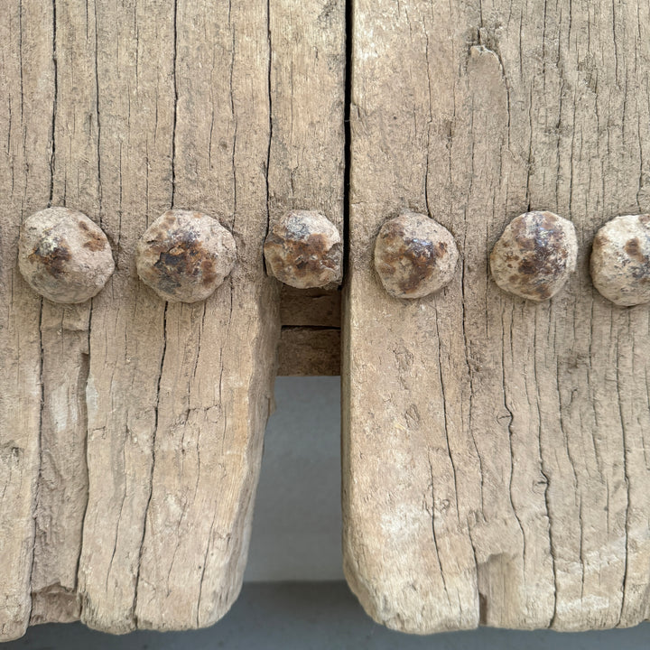 Close-up of wooden planks with metal rivets on a gray background