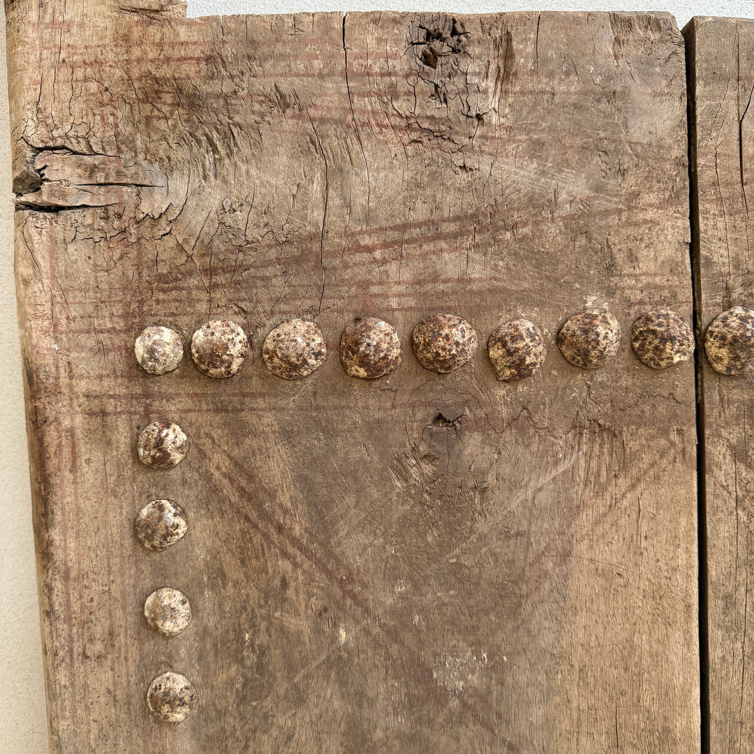 Wooden panel with metal studs arranged in a row
