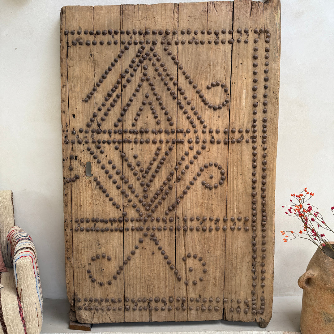 Decorative wooden panel with geometric patterns on a white wall.
