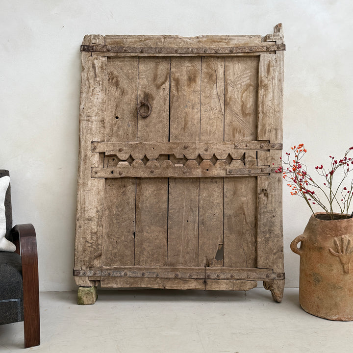 Vintage wooden cabinet with decorative elements in a room setting.