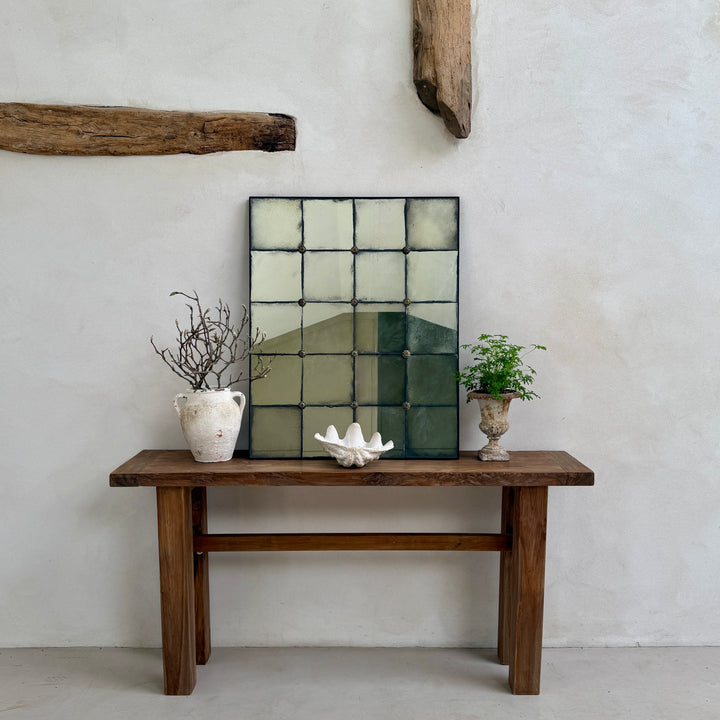 Leonora large decorative wall mirror with aged foxed mirror glass and brass rosettes, styled above a reclaimed teak console table in a light-filled country interior.
