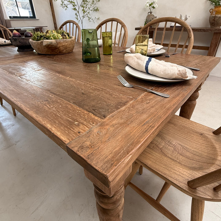 End view of the large reclaimed teak dining table showcasing its generous width, solid timber construction and elegant farmhouse-inspired design.
