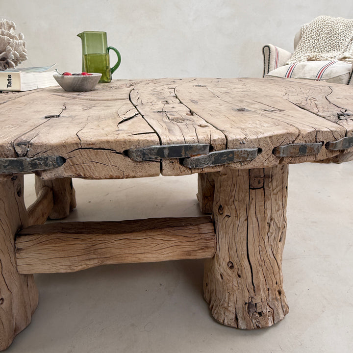Rustic wooden table with a textured surface in a room setting.