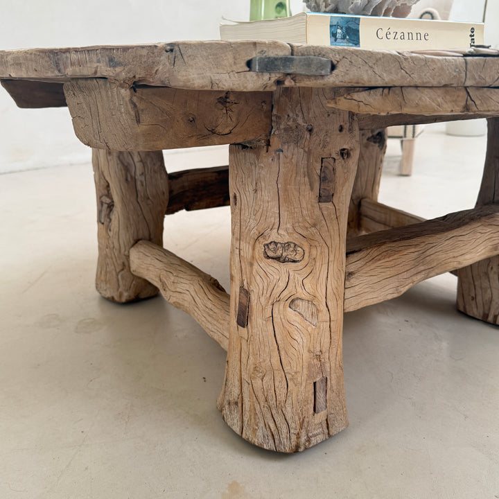Rustic wooden table with a natural, aged appearance on a light floor.