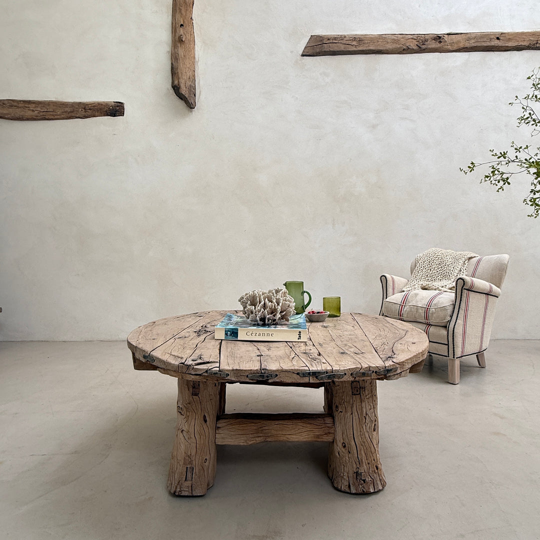 Rustic wooden table with a chair in a room with exposed beams.