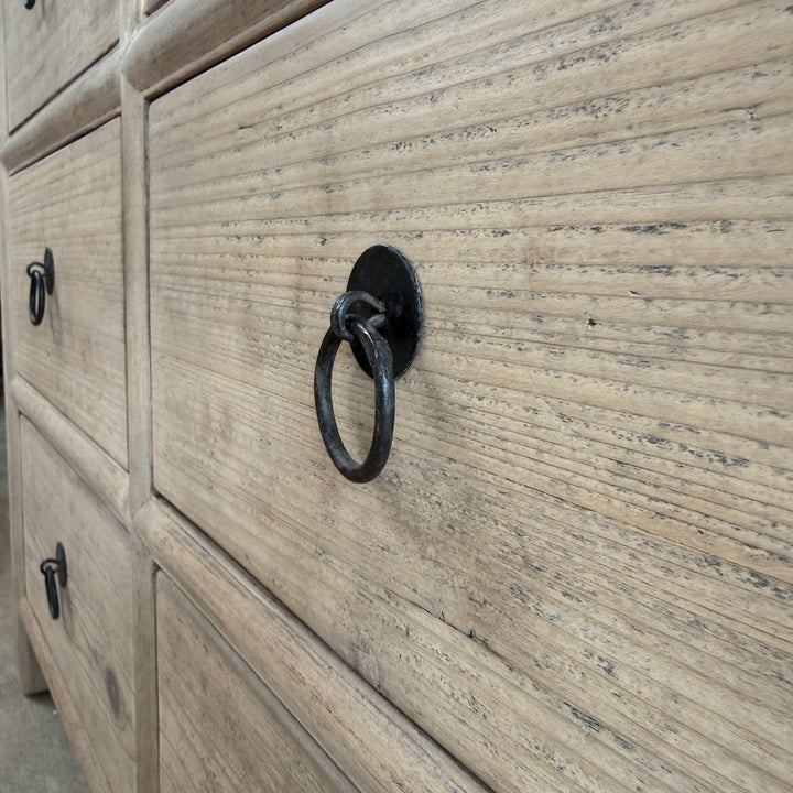 Wooden dresser with a textured finish and black metal ring handle.