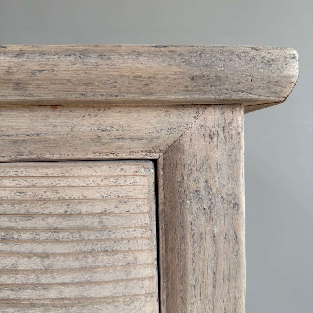 Close-up of a wooden cabinet with a gray background