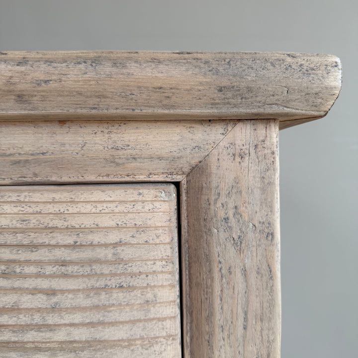 Close-up of a wooden cabinet with a gray background