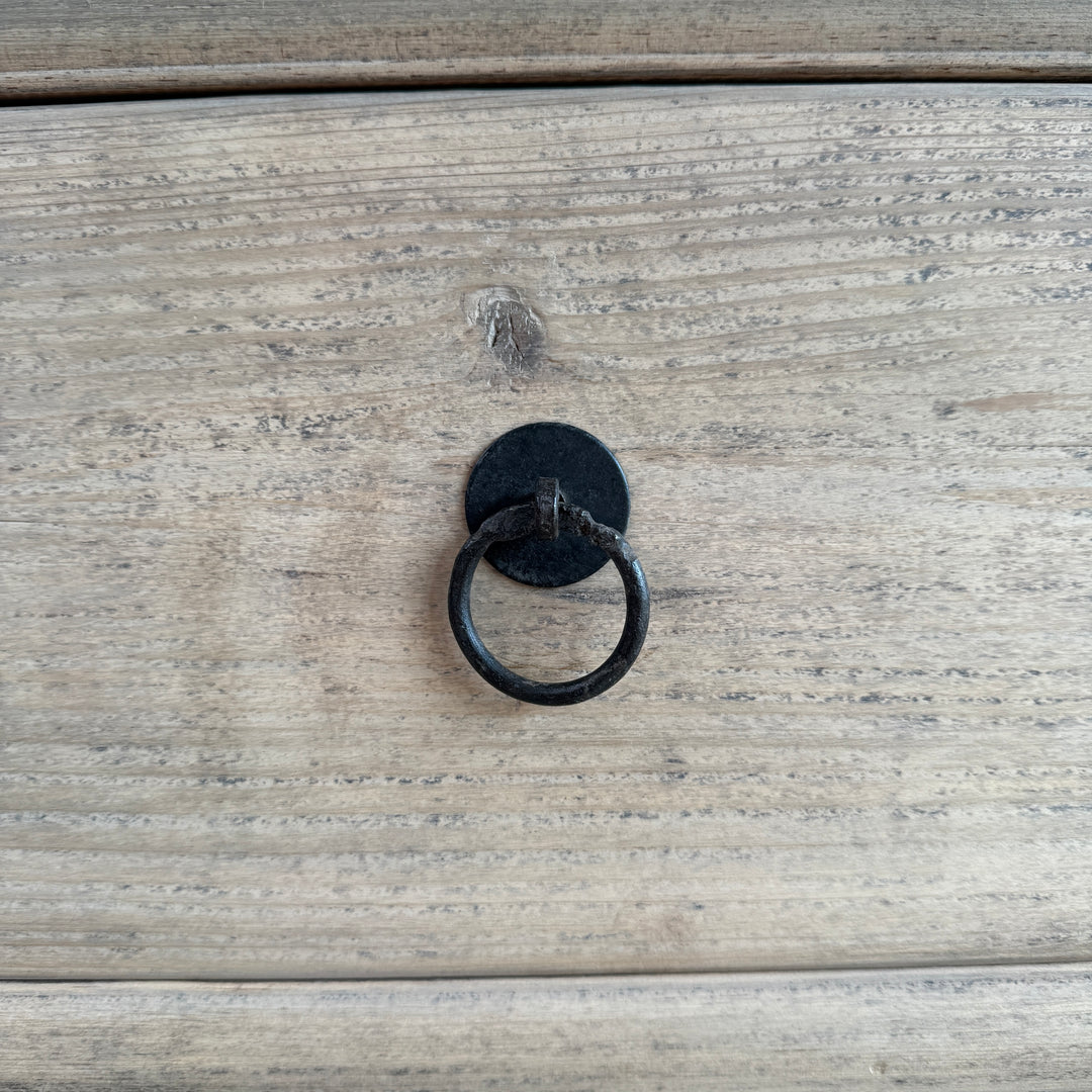 Black metal ring handle on a wooden surface