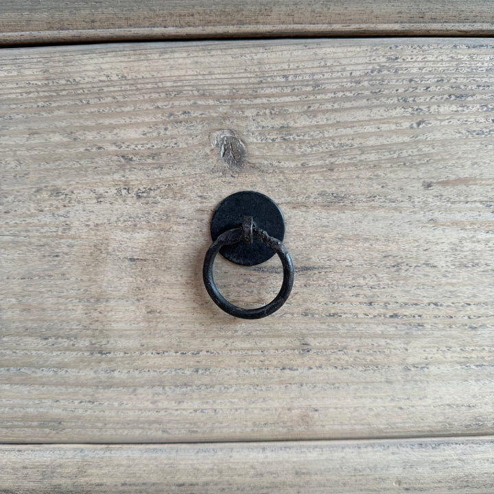 Black metal ring handle on a wooden surface