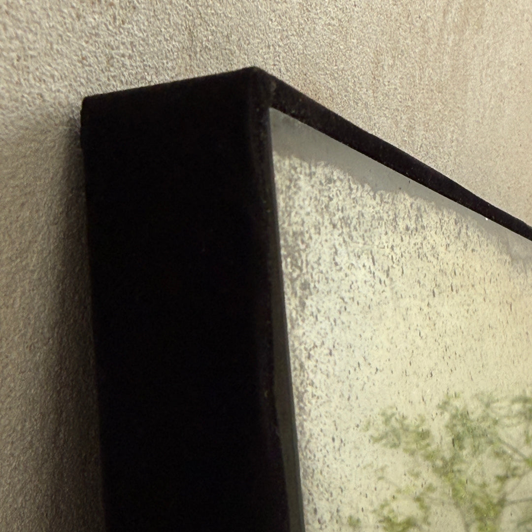 Close-up of the Leonora large foxed antiqued mirror showing the slim black metal frame and beautifully distressed antique mirror glass.