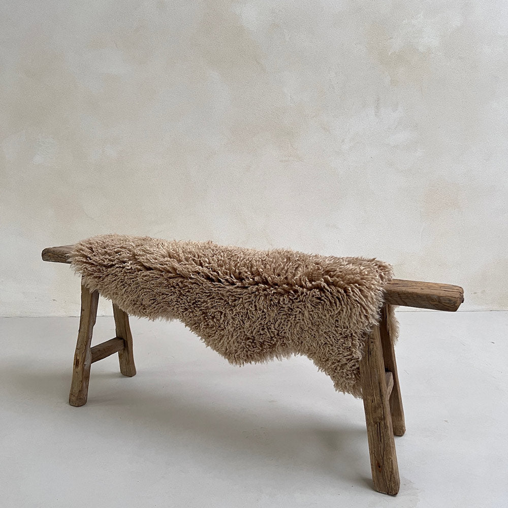Natural sheepskin throw rug on a bench