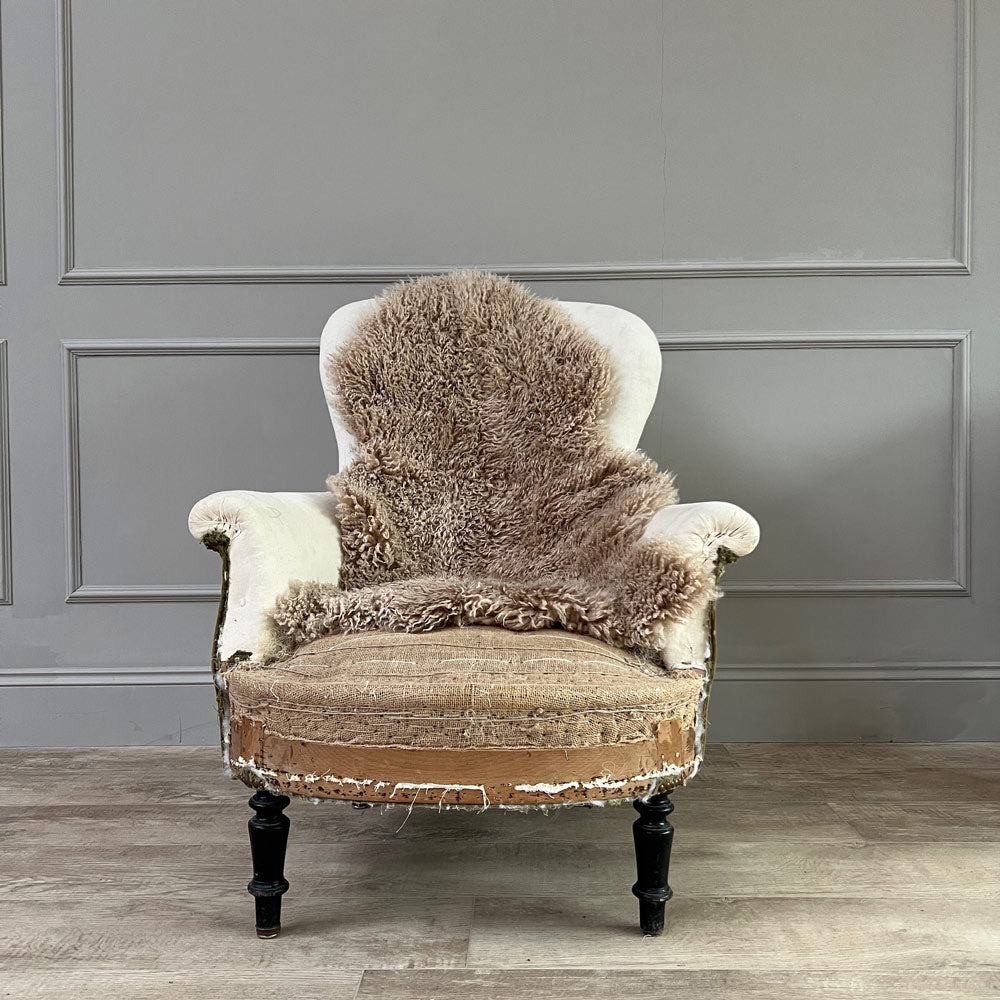 Natural sheepskin throw rug on a deconstructed armchair