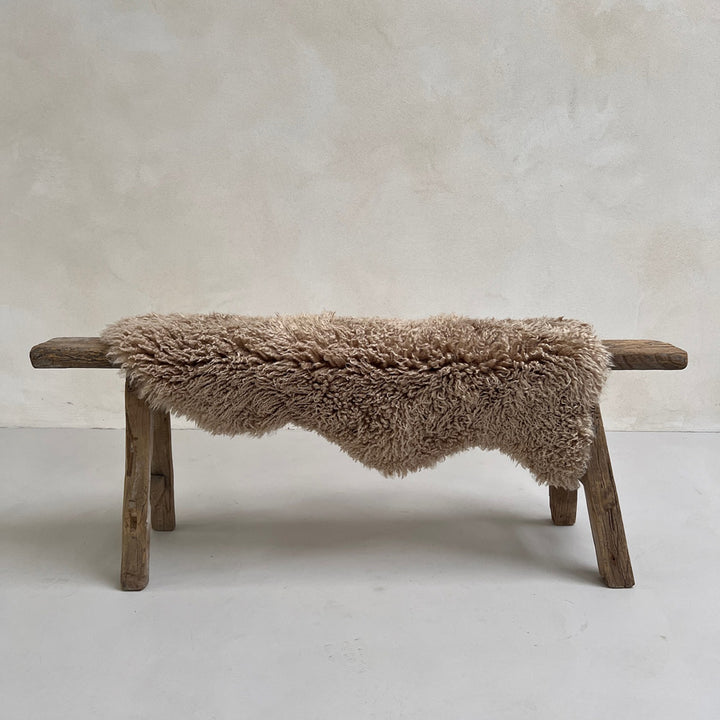 Natural sheepskin throw rug styled on a bench