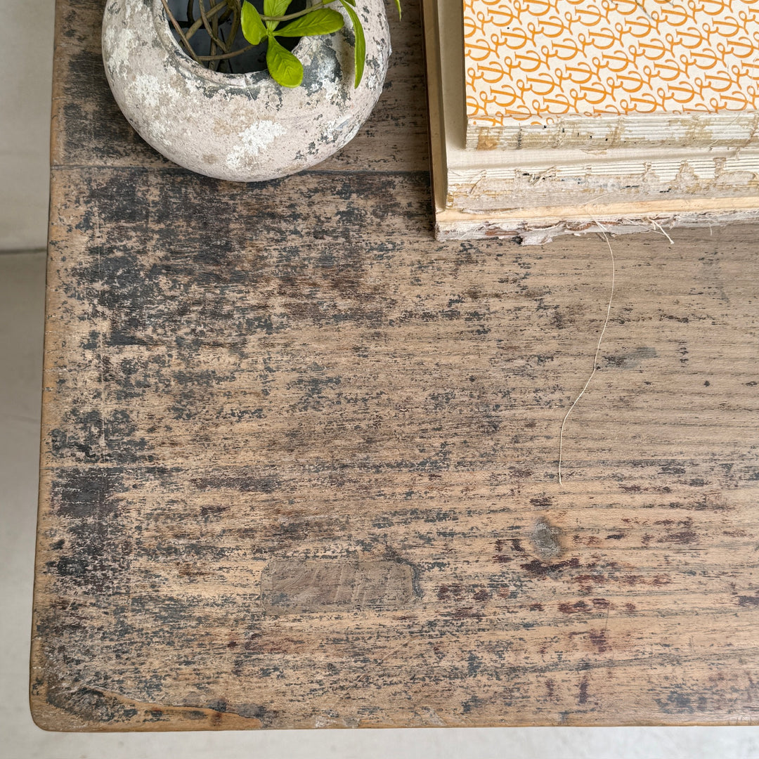 Worn wooden surface with a small plant pot and patterned box.