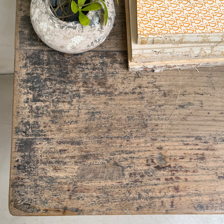 Worn wooden surface with a small plant pot and patterned box.