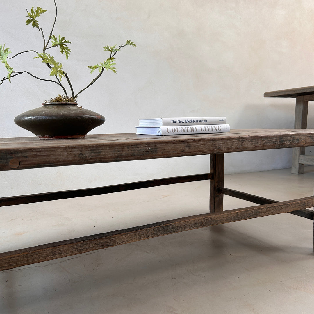 Close-up of the handcrafted leg and stretcher construction of the Reclaimed Elm Coffee Table, showcasing traditional craftsmanship and the enduring strength of reclaimed timber.