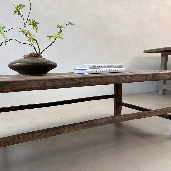 Close-up of the handcrafted leg and stretcher construction of the Reclaimed Elm Coffee Table, showcasing traditional craftsmanship and the enduring strength of reclaimed timber.