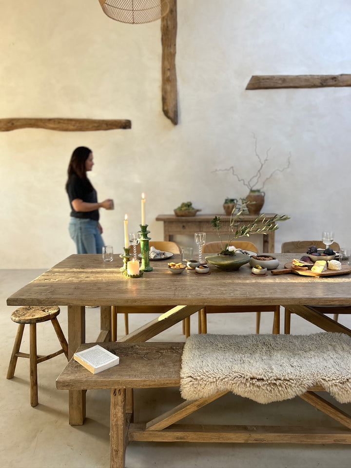 The rustic Reclaimed Elm Farmhouse Dining Table Cambridge styled within a light-filled farmhouse interior, showcasing the relaxed elegance of reclaimed elm furniture. A matching bench, natural textures and lived-in details demonstrate how this handcrafted dining table becomes a gathering place for everyday meals, entertaining and modern country living.