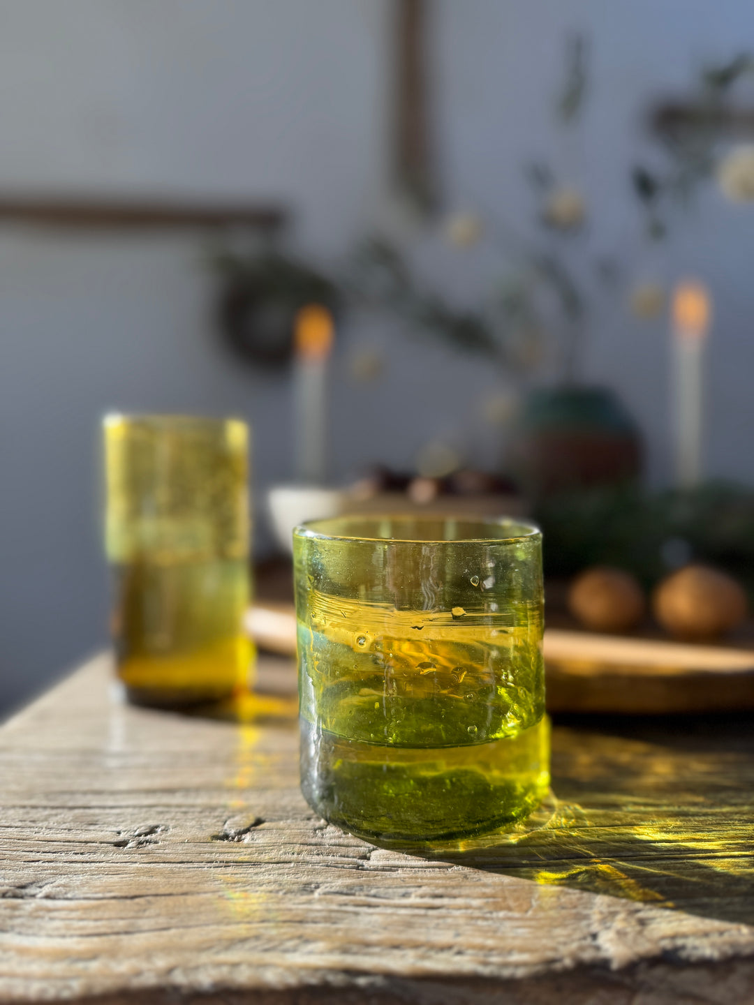 Sunlight filtering through hand-blown glassware on the Reclaimed Elm Farmhouse Dining Table Cambridge. Crafted from salvaged elm with a richly textured surface, this close-up captures the natural beauty, warmth and understated elegance of a timeless farmhouse dining table designed for relaxed entertaining and modern country living.