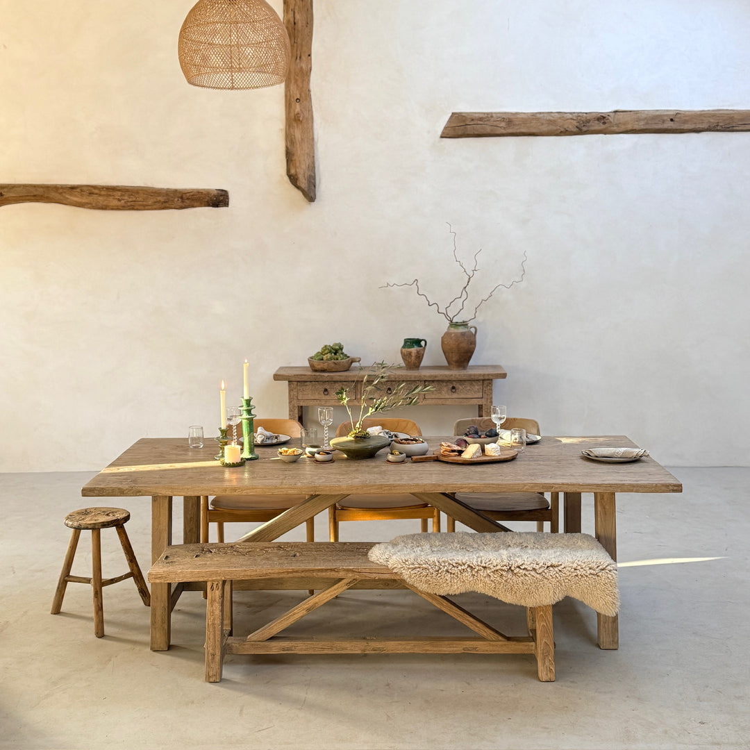 Reclaimed Elm Farmhouse Dining Table Cambridge with matching reclaimed elm bench, styled in a calm modern barn interior. Crafted from salvaged elm timber with a timeless farmhouse design, this solid wood dining table creates a welcoming space for family meals, entertaining and everyday living.