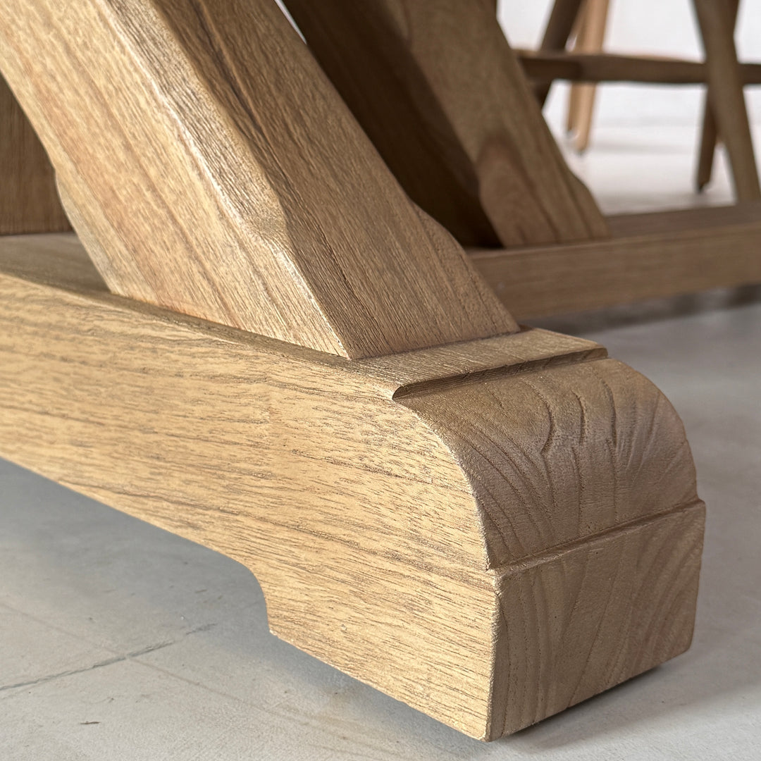 Close-up of the solid oak dining table base showing the angled timber support and substantial shaped wooden foot.
