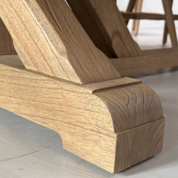 Close-up of the solid oak dining table base showing the angled timber support and substantial shaped wooden foot.