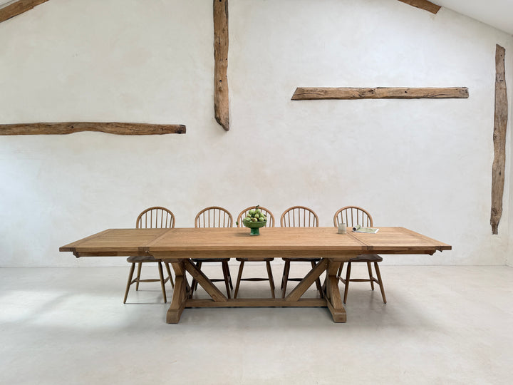 Reclaimed oak extending dining table styled for relaxed family dining with wooden chairs and seasonal floral arrangements.