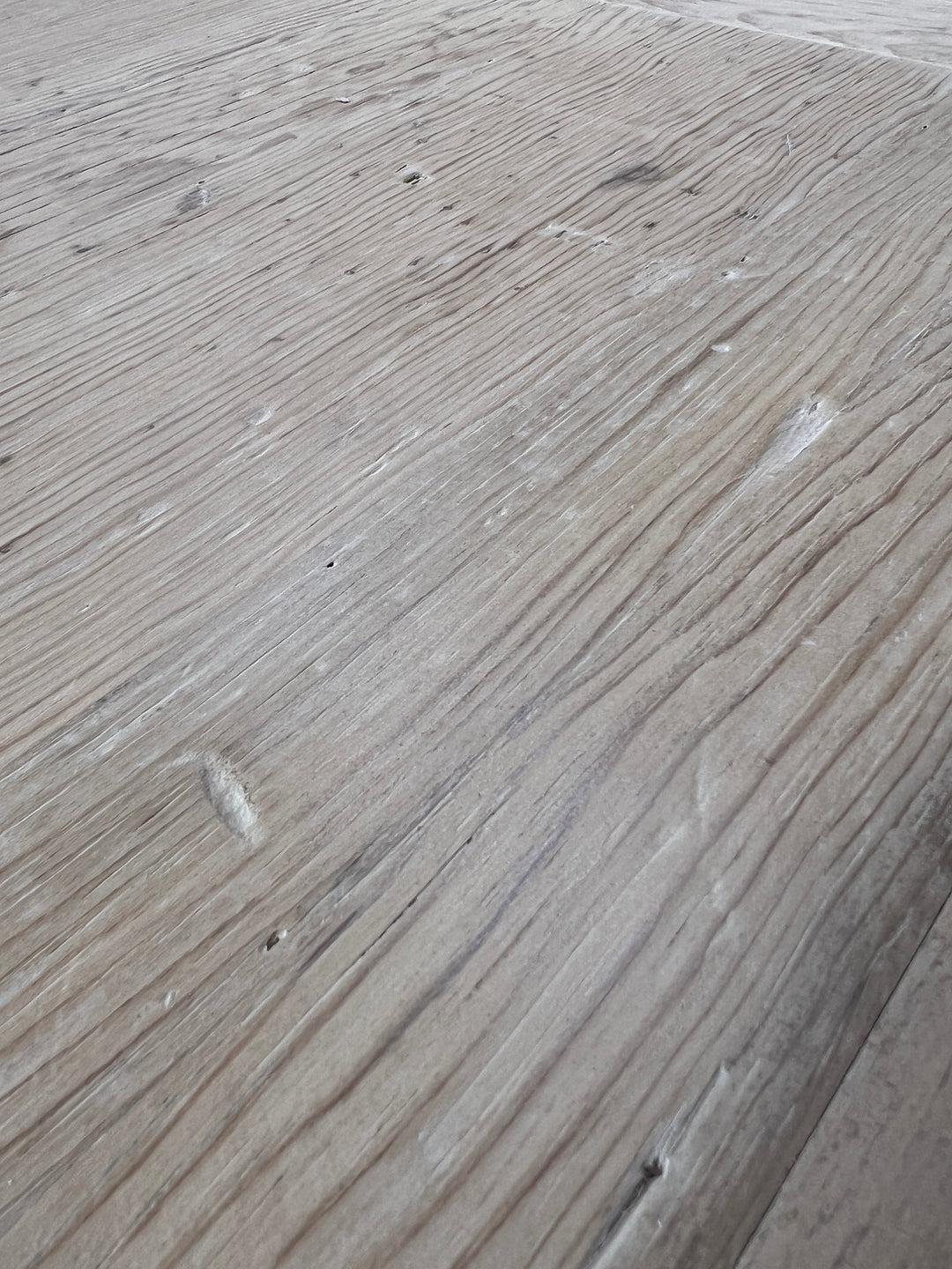 Close up of reclaimed pine dining tabletop revealing beautifully aged grain and individual timber character