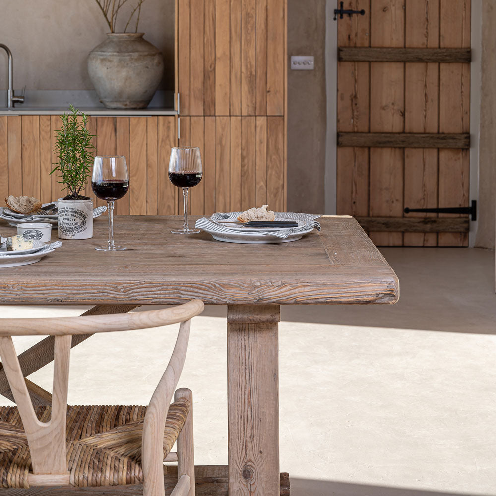Generous reclaimed pine dining table styled for relaxed entertaining with characterful timber surface