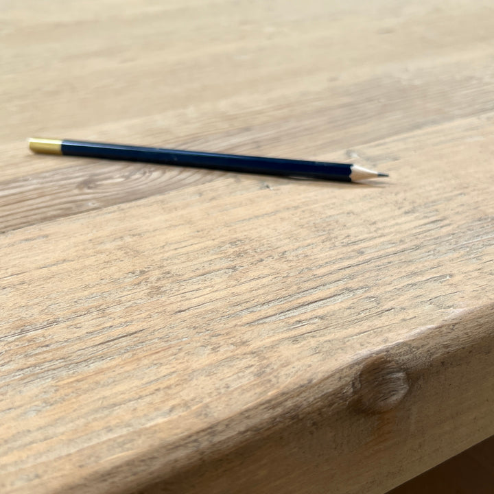 Detailed view of the substantial reclaimed pine refectory tabletop edge and naturally aged finish