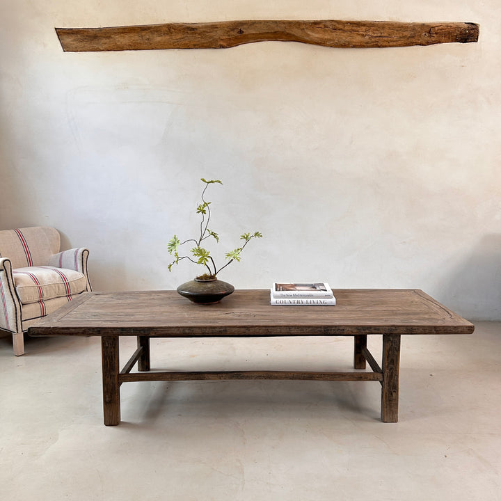 Large reclaimed wood coffee table handcrafted from salvaged timber with a rustic weathered finish, styled in a contemporary country living room.