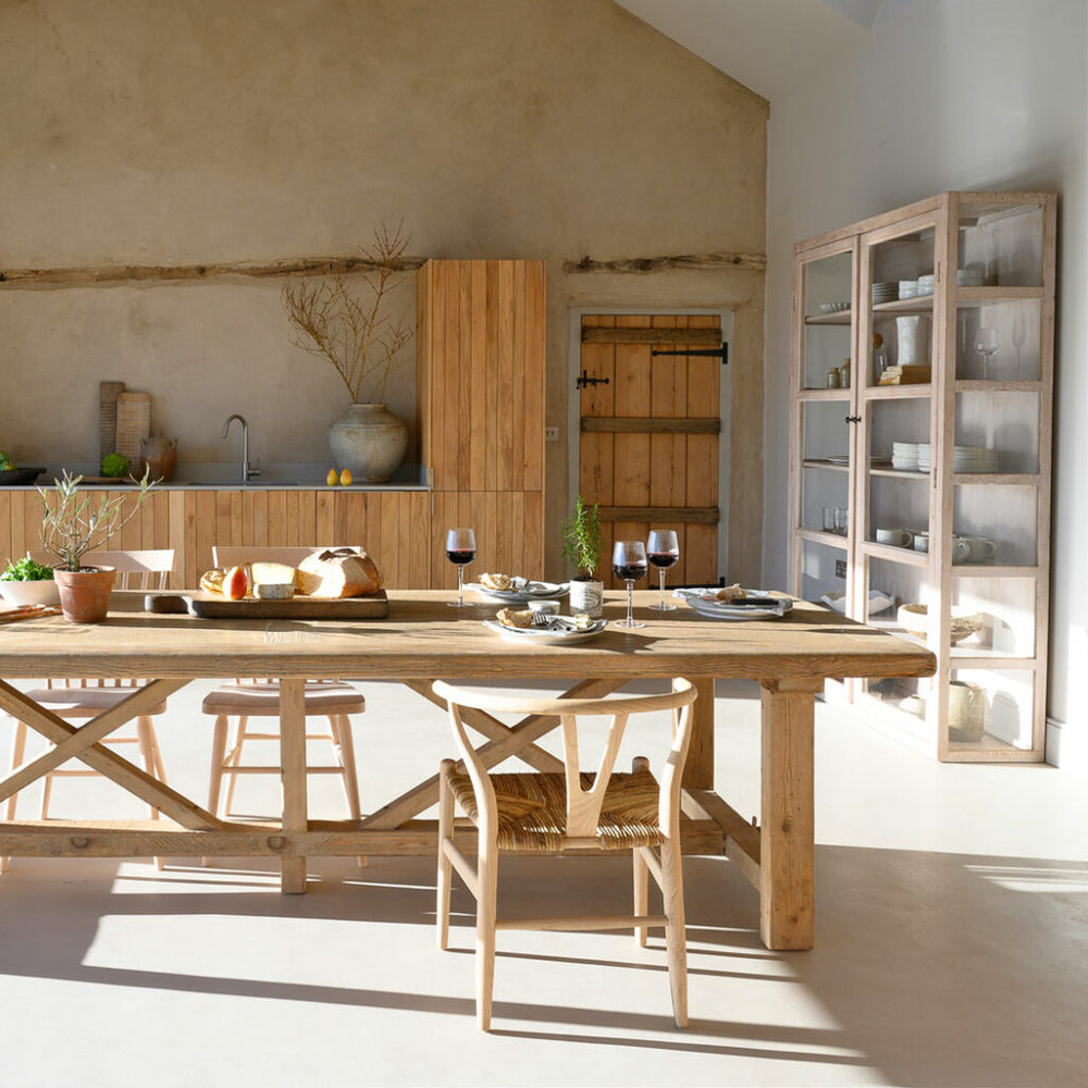 Reclaimed wood refectory dining table styled for relaxed family dining in a modern rustic kitchen