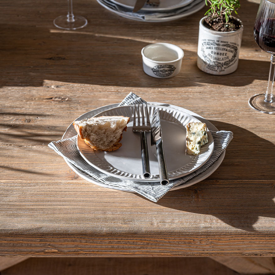 Rustic reclaimed wood refectory tabletop styled for dining with naturally aged pine character