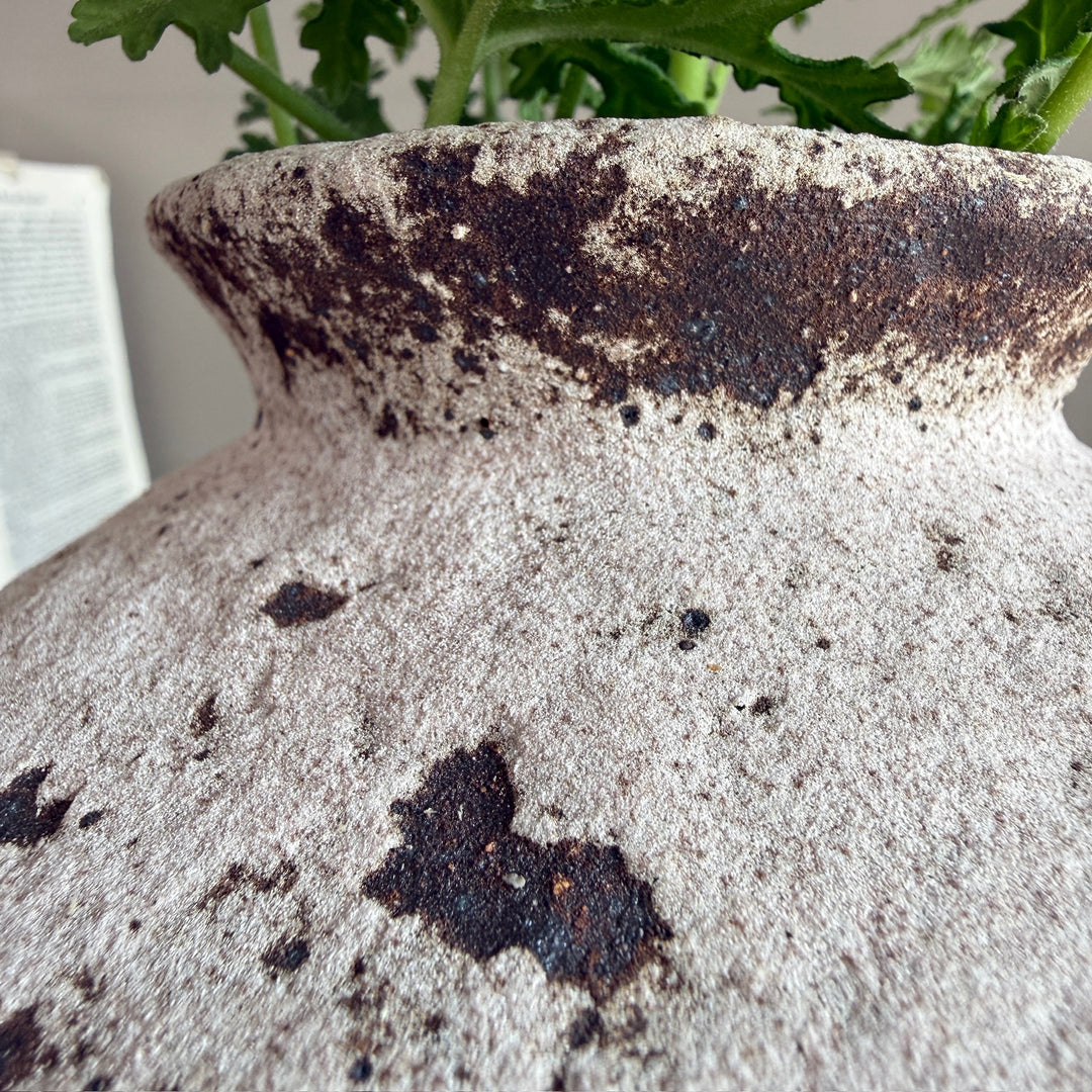Detailed view of the distressed stoneware surface, highlighting the aged finish and unique handcrafted character of the decorative vase.
