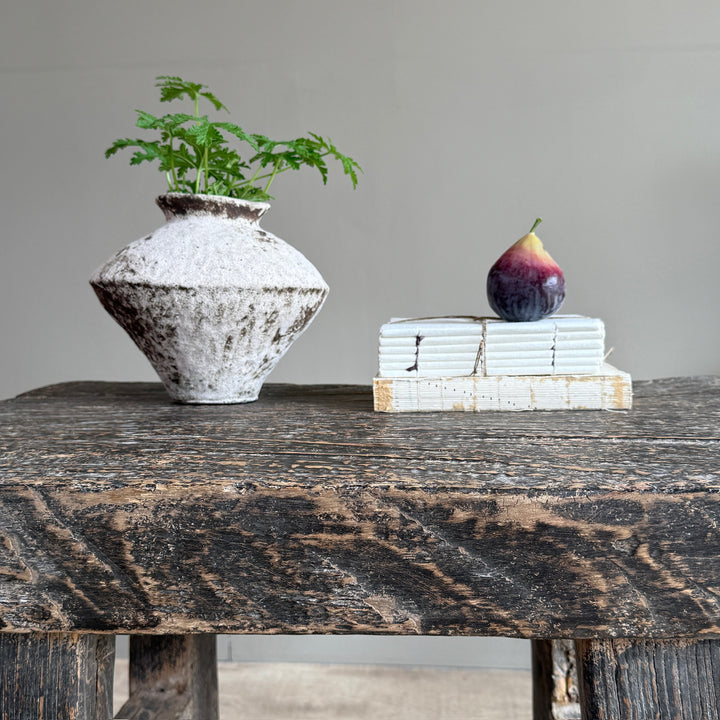 Rustic stoneware decorative vase styled on a reclaimed console table with decorative books and accessories in a contemporary country home.
