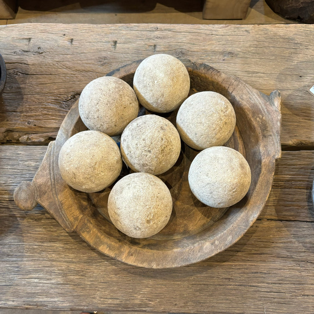 Rustic aged sandstone sphere aerial photo of the smaller size spheres in an antique wooden bowl