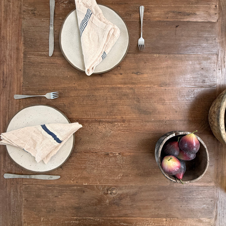 detail of the salvaged teak dining table revealing softly finished edges, rich teak grain and the unique markings that make every table one of a kind.