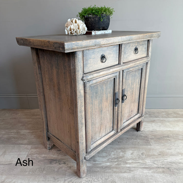 Wooden sideboard with two drawers and a door on a wooden floor.