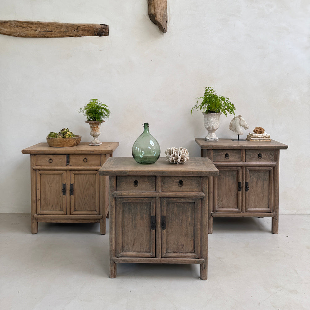 Wooden dresser with multiple drawers and a white wall background