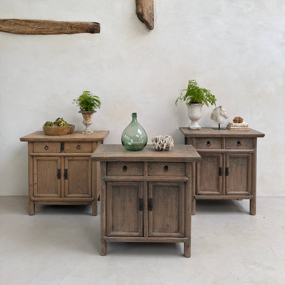 Wooden dresser with multiple drawers and a white wall background