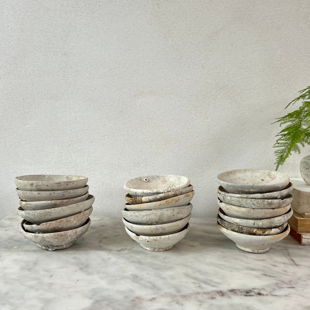 Stacks of ceramic bowls on a marble surface with a neutral background