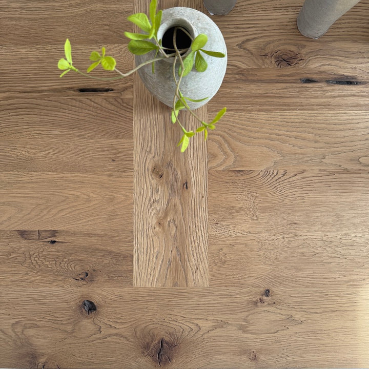 Reclaimed oak boards on the Suffolk dining table showing natural grain and tonal variation from overhead 