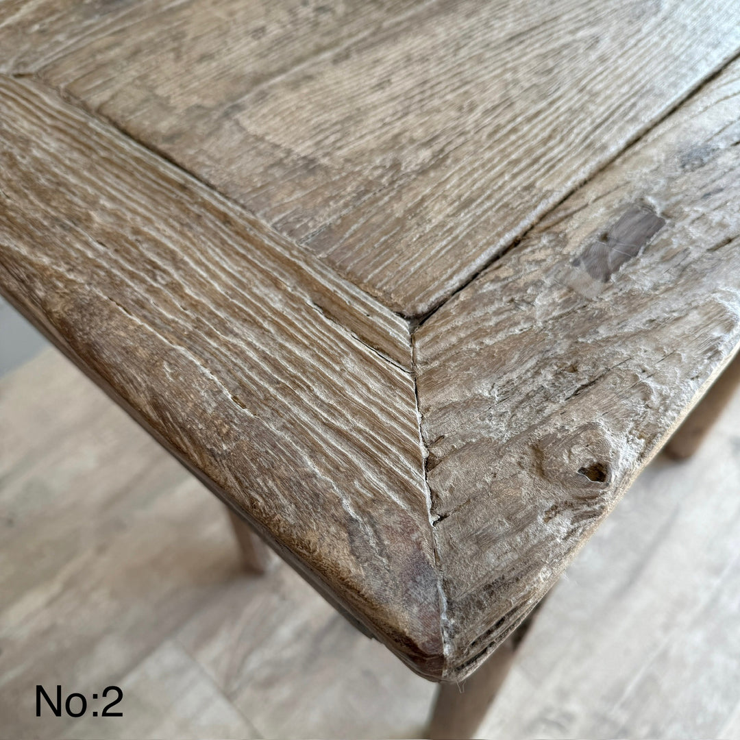 Close-up of a wooden stool with a rustic finish on a light background